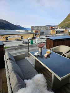 a couch and a table on a balcony with a view at Toppleiligheit - Eidsgata 49 in Nordfjordeid