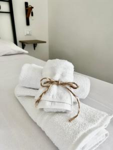 Ein Stapel Handtücher, mit einer Schleife zusammengebunden, liegt auf einem Bett. in der Unterkunft Dimora Dante in Amantea