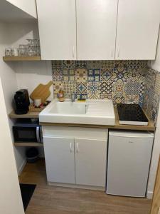 a kitchen with white cabinets and a sink at Maison de charme in Ambleny