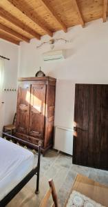 a bedroom with a bed and a wooden cabinet at Aunt Maria's in Pano Lefkara