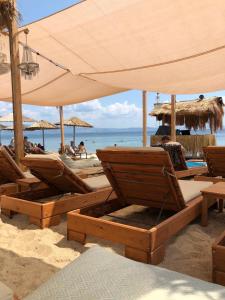 a group of chairs and umbrellas on a beach at Casa Portokali Chalkidiki - Modern Comfort with Authentic Greek Charm in Nea Potidaea