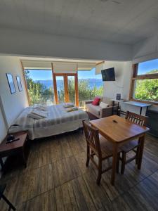 a bedroom with a bed and a table and a couch at Melipal Schuss ARG41 in San Carlos de Bariloche