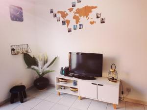 a flat screen tv sitting on top of a white cabinet at Petite maison cosy 4 couchages à 700 m de la plage in Torreilles