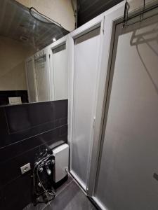 a bathroom with a shower stall and a toilet at Alpi Hostel in Skopje