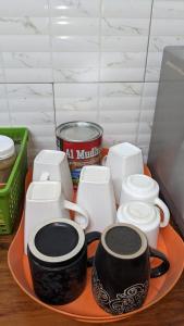 a tray of coffee cups and mugs on a counter at KINYANJUI HOMES OO2 in Morogoro