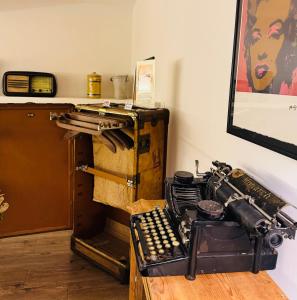 una habitación con una vieja máquina de escribir sobre una mesa en AQUAROOMS Luxury Suites, en Palermo