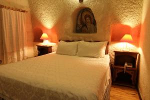 a bedroom with a bed and two night stands with lamps at Ascension Cave Suites - Special Class in Göreme