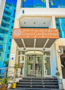 un edificio verde con giardino con un cartello sopra di GREEN GARDEN HOTEL a Doha