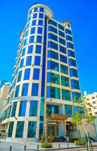 GREEN GARDEN HOTEL في الدوحة: مبنى طويل مع سماء زرقاء في الخلفية