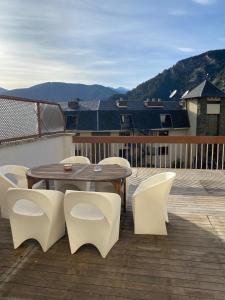 a wooden deck with a wooden table and white chairs at appartement Terrasse 1 chambre ORDINO HUT3-008298 in Ordino