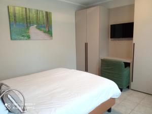 1 dormitorio con 1 cama y TV de pantalla plana en Appart-Hotel Gwendy, en Bour