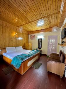 a bedroom with a large bed and a couch at Valley View rooms near Khajjiar Lake in Lāhri
