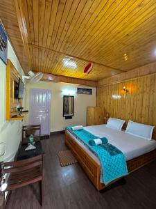 a bedroom with a large bed with a wooden ceiling at Valley View rooms near Khajjiar Lake in Lāhri