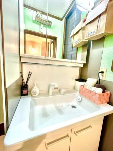 y baño con lavabo blanco y espejo. en Best location !private room in Jujo shopping street for max 6 people, en Tokio