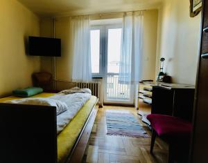 sypialnia z łóżkiem i dużym oknem w obiekcie Villa Romano w Kielcach