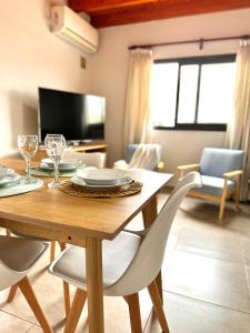 uma sala de jantar com uma mesa de madeira e cadeiras em Departamento en complejo semiprivado con cochera em Guaymallén