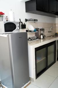 uma cozinha com um micro-ondas e um fogão forno superior em appartement cosy moon bonapriso em Douala