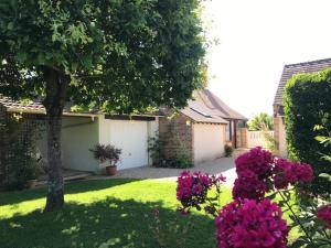 Sologne des étangs - Bontens في Saint-Viâtre: منزل مع ساحة بها زهور أرجوانية وشجرة