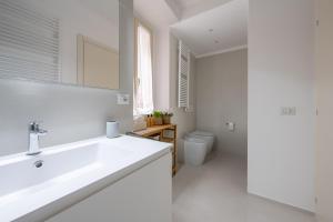 une salle de bain blanche avec un lavabo et des toilettes dans l'établissement New stone house lake view - 1, à Lezzeno 29 autres photos