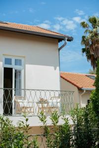 a balcony of a house with chairs and a palm tree at Boutique Hôtel Villa Fabulite in Antibes
