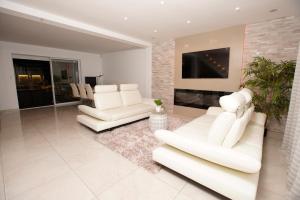 a living room with two white couches and a fireplace at Magnifique maison de vacances à paris in Paray-Vieille-Poste