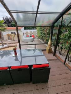 a glass house with a table and chairs on a deck at Magnifique maison de vacances à paris in Paray-Vieille-Poste