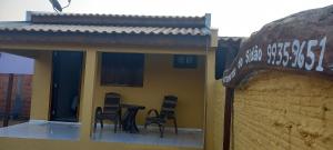 a yellow building with chairs and a table on a balcony at Pousada do Sidão in Nobres