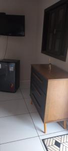 ein Wohnzimmer mit einem TV und einer Kommode mit einer Kommode in der Unterkunft Pousada do Sidão in Nobres