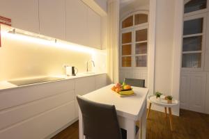 una cocina con una mesa con un bol de fruta. en Casa Guerreiro - Regina Hotel Group en Viana do Castelo