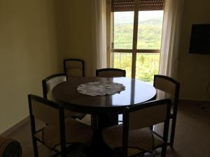 une table à manger avec des chaises et une fenêtre dans l'établissement Bellavista (grande), à Barete