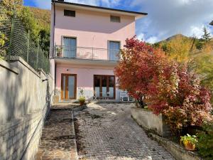 une maison rose avec un chemin en pierre devant elle dans l'établissement Bellavista (grande), à Barete