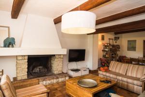 a living room with a couch and a fireplace at Mas dans la campagne pour loisirs et télétravail in Sarrians