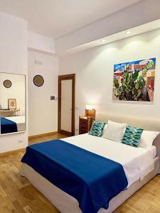 a bedroom with a large bed with a blue blanket at Qurchiti in Capo dʼOrlando