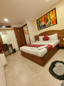 a bedroom with a bed and a painting on the wall at Hotel Beach Crown Juhu in Mumbai