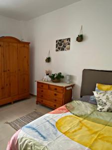 um quarto com uma cama e uma cómoda em madeira em Amanecer Isleño Habitaciones em Arrecife