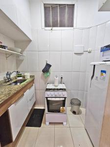 una pequeña cocina con fogones y fregadero en Apartamento na Praia do Flamengo en Río de Janeiro