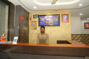 a man standing at the counter of a restaurant at Hotel Sai hiira in Rewa