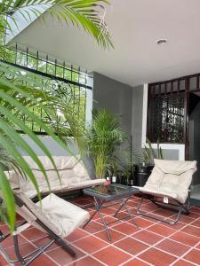 a room with two chairs and a table and plants at Apartamento moderno cerca al aeropuerto in Neiva