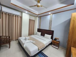 1 dormitorio con 1 cama grande y techo en Hotel S.A International, en Cox's Bazar