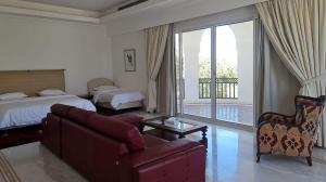 a bedroom with a couch and a bed and a balcony at Beit Al-Madina in Al ‘Uyūn