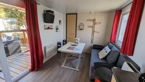 a living room with a couch and a table at MH camping 4 étoile Mer/forêt in Soulac-sur-Mer