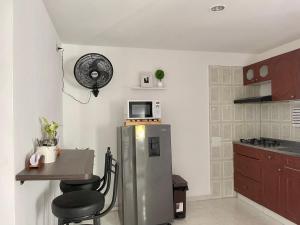 una cucina con frigorifero, tavolo e forno a microonde di Apartamento moderno cerca al aeropuerto a Neiva