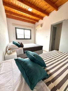 um quarto com duas camas com almofadas em Departamento en complejo semiprivado con cochera em Guaymallén
