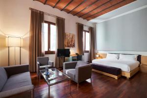 a hotel room with a bed and a living room at Mercer House Bòria BCN in Barcelona