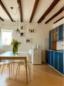 a kitchen with blue cabinets and a table and chairs at Casa Plava sea view apartment in Rovinj