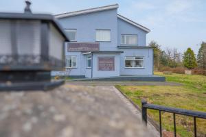 een blauw huis met een bord ervoor bij Queensferry Guest house in Rosyth