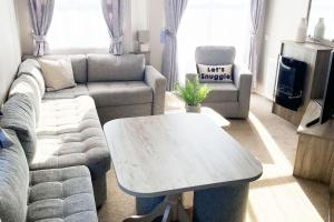 a living room with a couch and a coffee table at Scottish Holiday Home in Ardeer Square