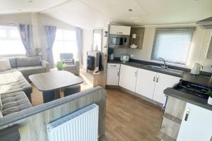 a kitchen and living room with a couch and a table at Scottish Holiday Home in Ardeer Square