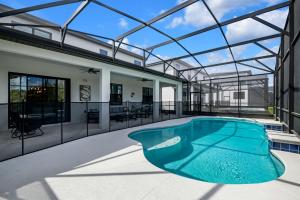 una piscina cubierta en una casa con techo de cristal en Orlando's Best Escape Residence at Paradiso Grande Resort home, en Orlando