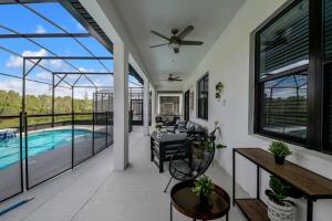sala de estar con piscina y ventilador de techo en Orlando's Best Escape Residence at Paradiso Grande Resort home, en Orlando